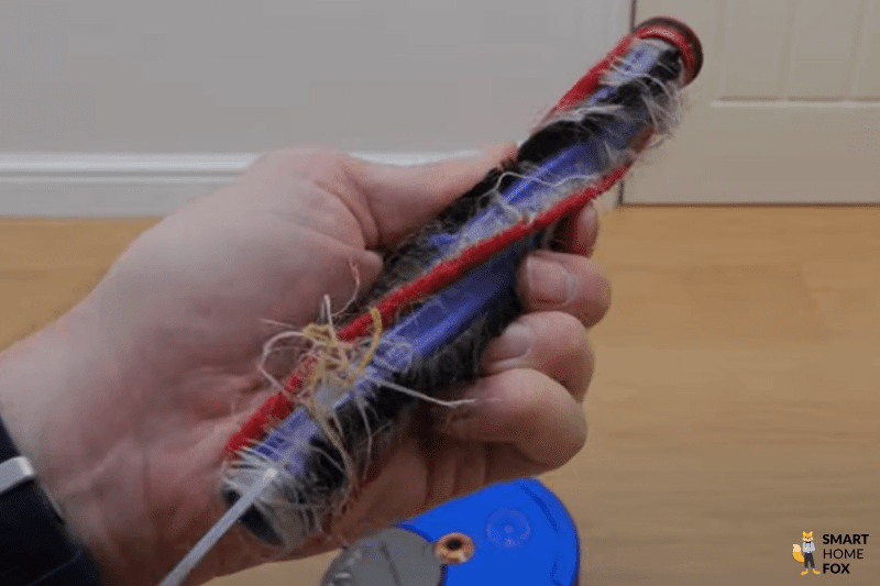 Hair is removed from a robot vacuum brush.